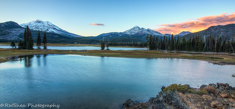 Sparks Lake on a sunny day. It's near sunset and the clouds are tinged a pretty pink.