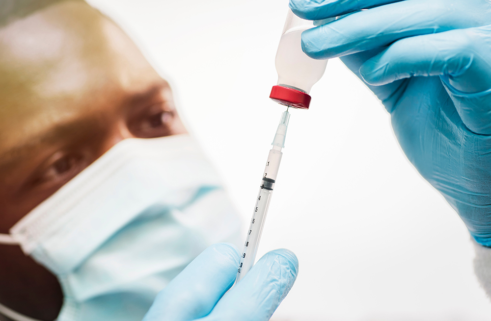 Vaccine concept, african american doctor drawing vaccination int A man drawing a vaccine with a needle for Covid 19