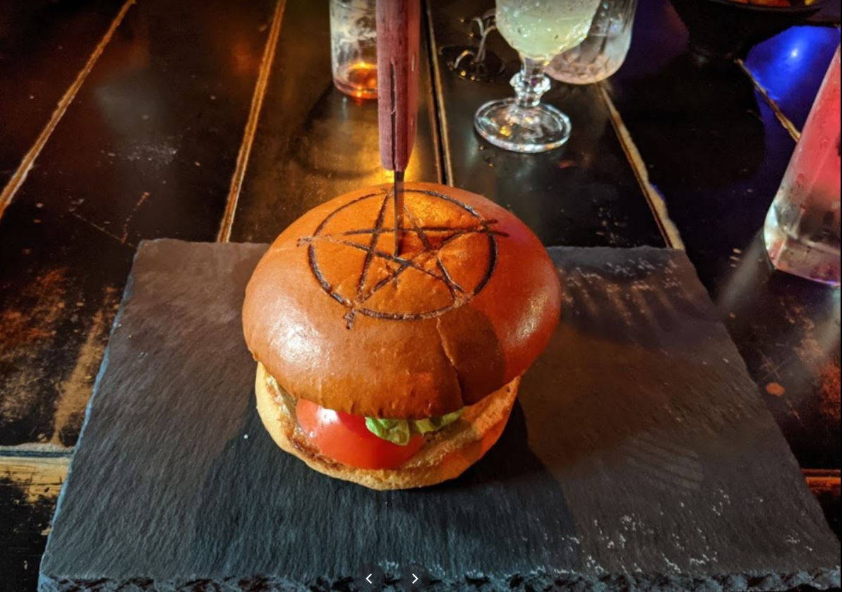 Raven's Manor Raven's Manor a burger with a pentagram bun and knife portland oregon