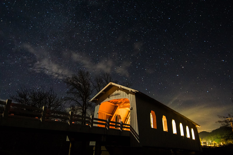 Grave Creek Covered Bridge at night with stars overhead.