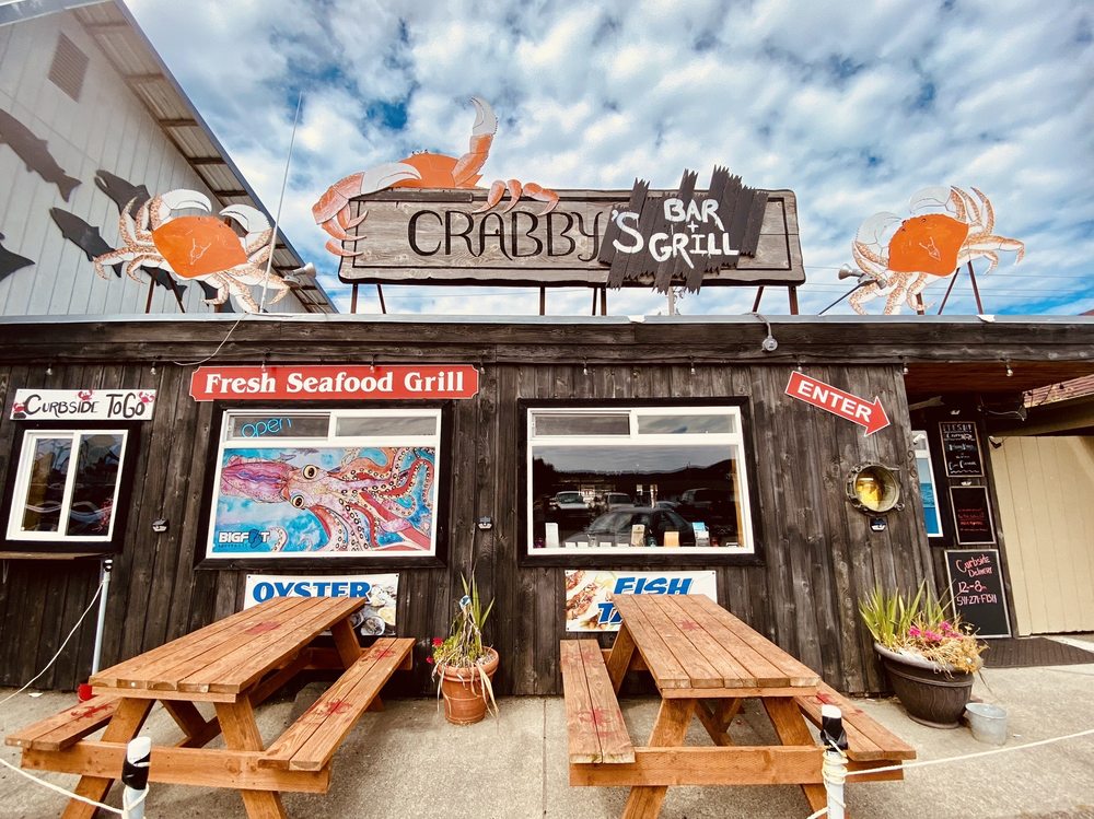 Crabby’s Bar And Grill. Photo by Lorrie P. via Yelp. The outside of Crabby's Bar And GRill. It has wood siding, nice wooden signs, accents of red, blue and orange. There are painted crabs and two wooden picnic tables.