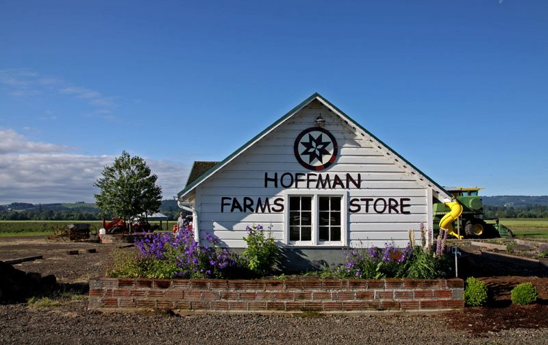 Hoffman Farms Store Beaverton The outside of Hoffman Farms Store. It's a white wood building. There are purple plants outside.