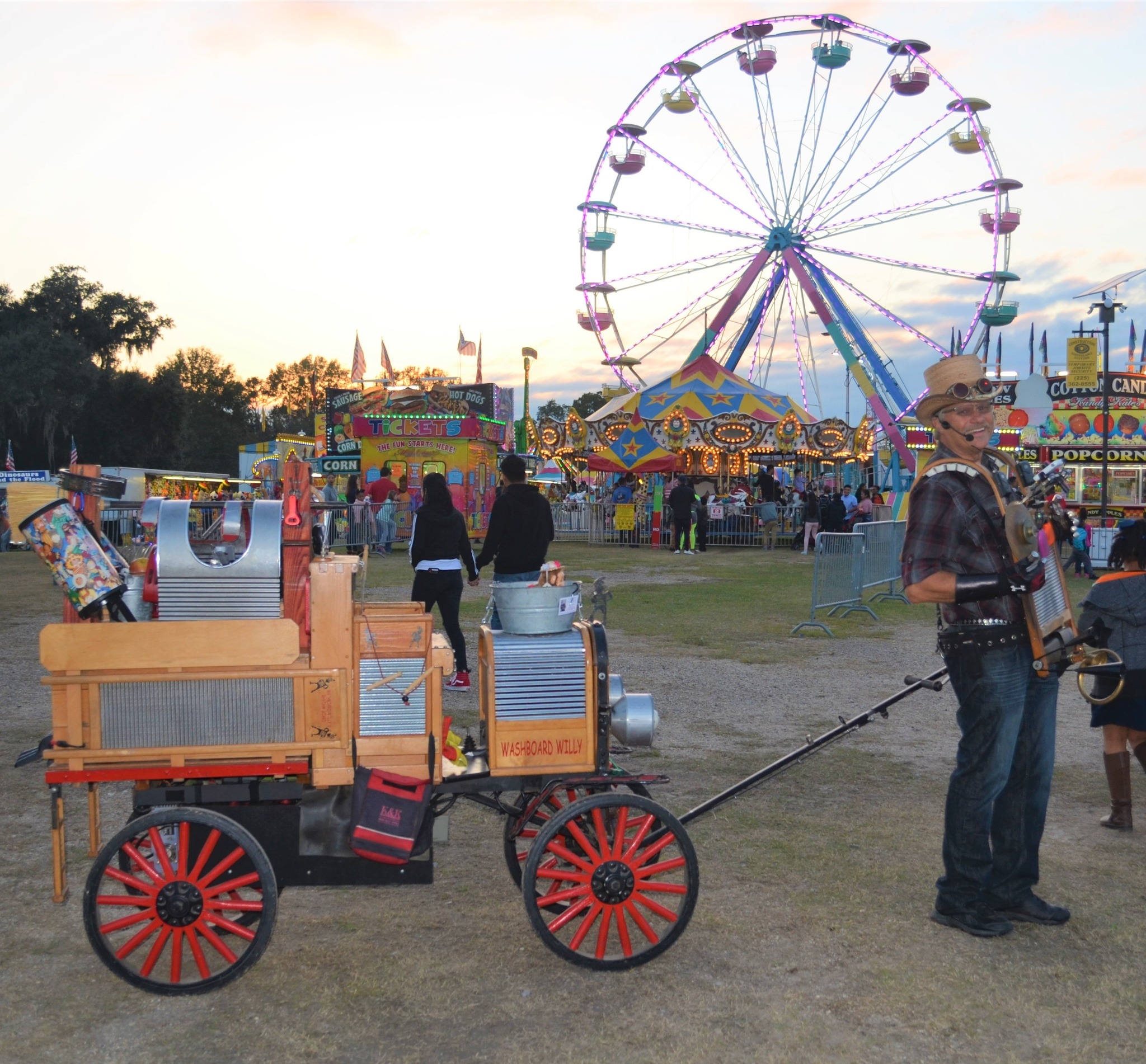 Yamhill County Fair & Rodeo A man pulling a wagon stands in front of the Ferris wheel at the county fair.
