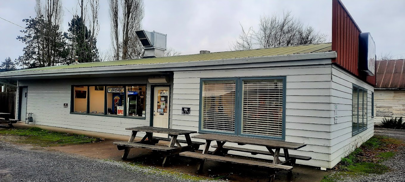 Photo by T via Google Local. The outside of Tammy D's. It's an unassuming white building with two wooden picnic tables outside.