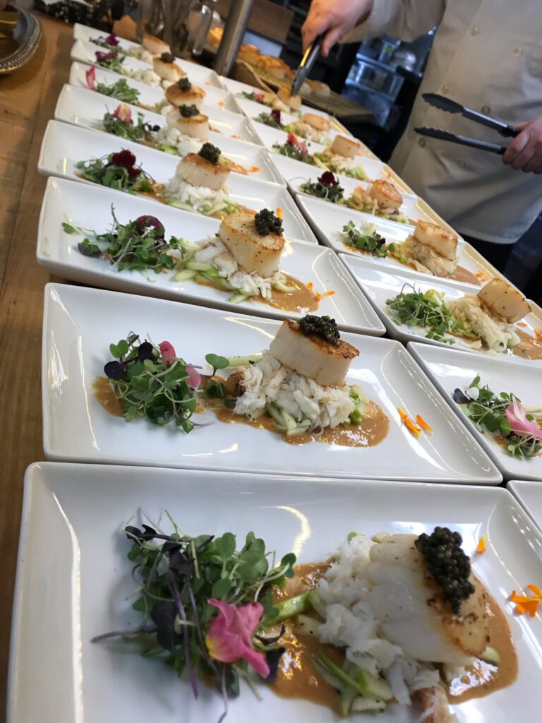 More than a dozen plates lined up with delicious looking food.