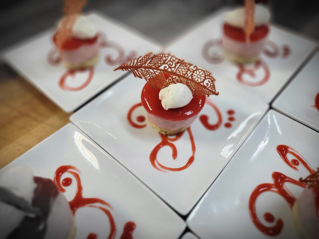 A desert on a white plate with a red sauce.