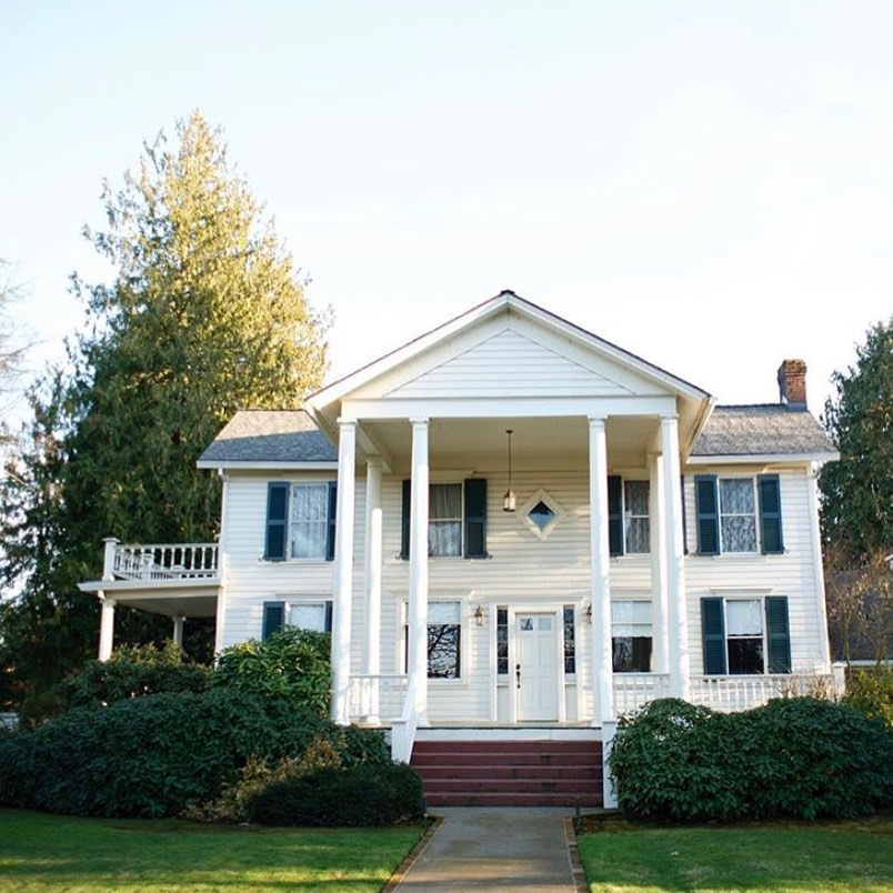 The outside of the Joel Palmer House. It's two stories, white, and has white pillars on the front porch.