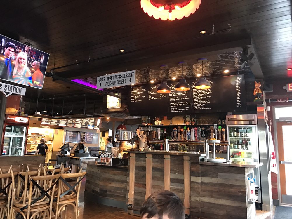 The interior of Bill and Tim's. There's wooden furniture and accents on the walls. It gives off a warm cozy vibe.