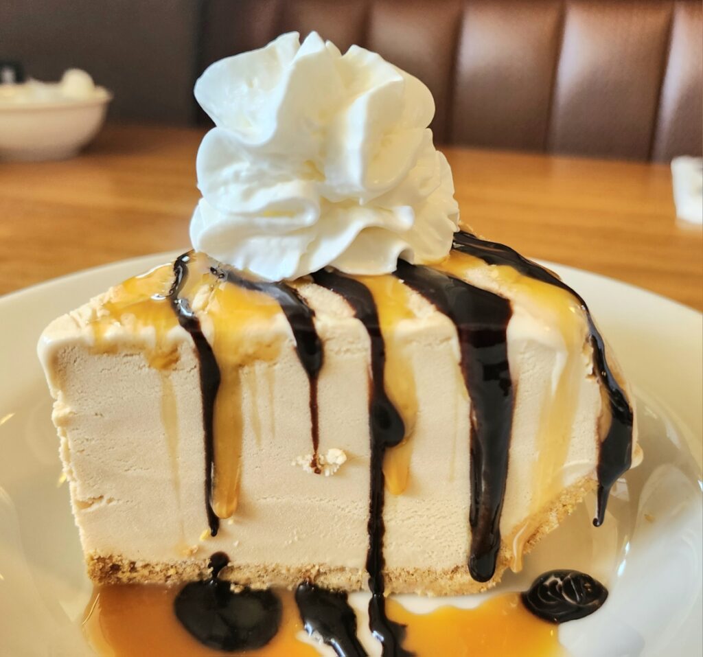 Banning's Restaurant, Tigard Oregon, Good Eats, Comfort Food, Best Places To Eat, Famous Pie House, Old School Diners, Portland Area, Where to Eat in Tigard, A piece of pie with chocolate and caramel drizzled over the top and down the sides. It has a dollop of whip cream on top.