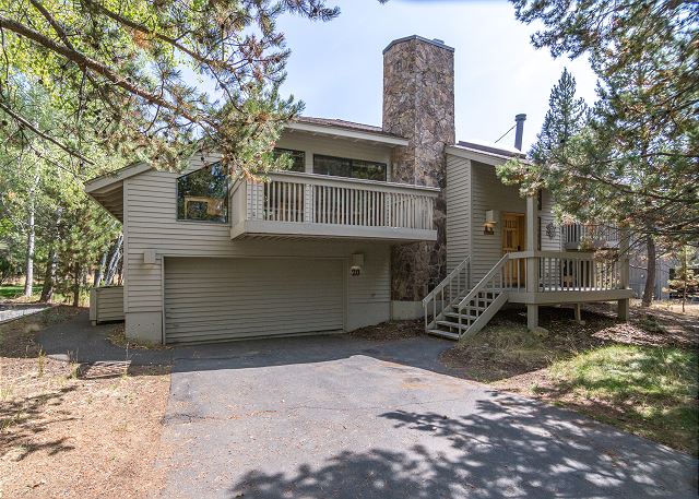 The exterior of Hickory #20. It's a gray two story building with a two car garage, a covered front porch, and a balcony over the garage door.
