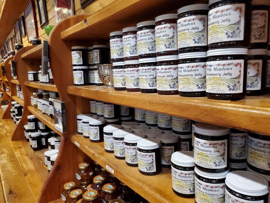 The interior of the store. It's all wood and looks like a cute wood cabin inside. There are shelves and shelves (all wood) packed with homemade jams and jellies.