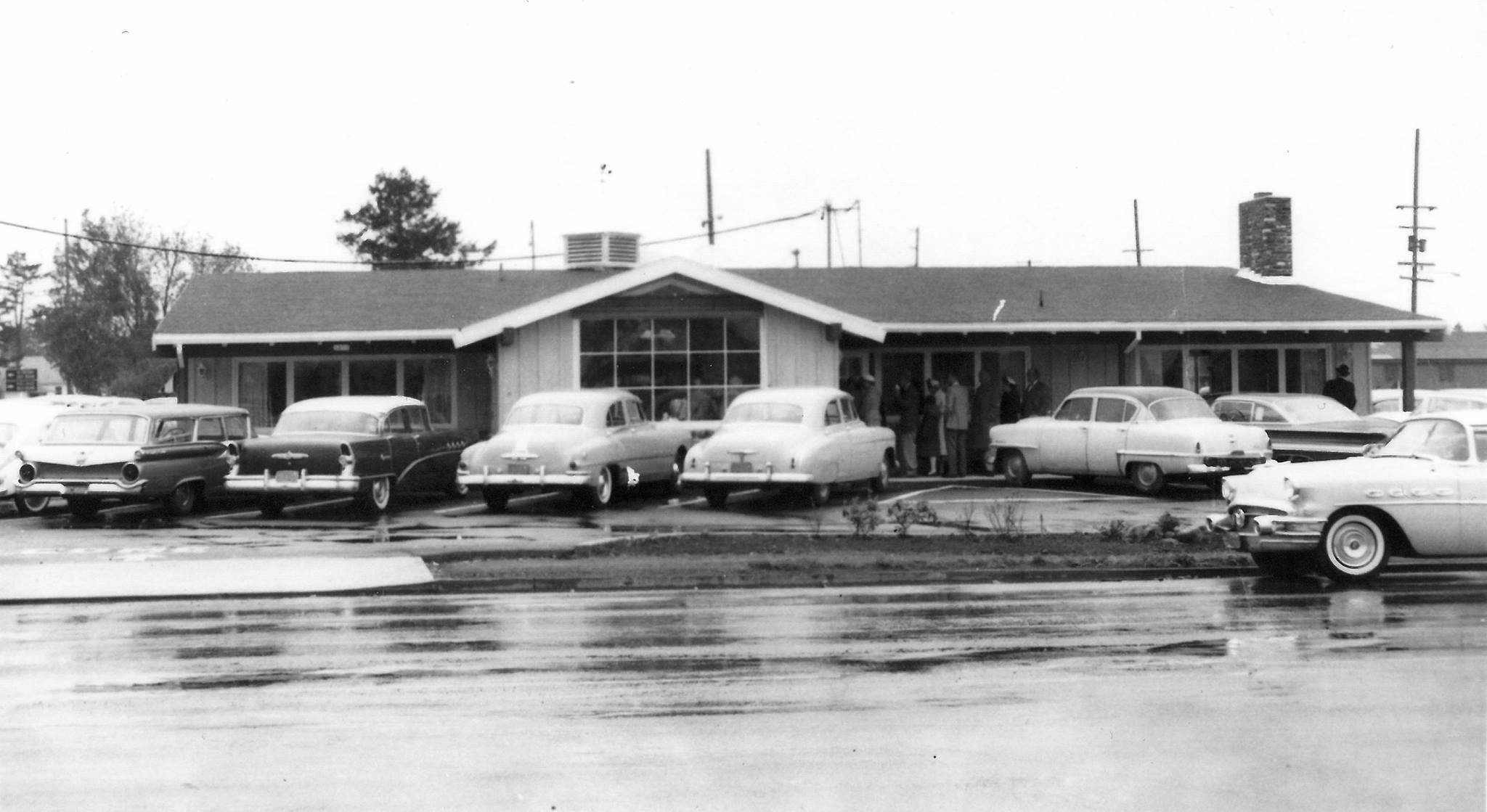 Photo via the Elmer’s Restaurant Facebook page A black and white photo of Elmer's Restaurant in 1962. There are several cars parked outside and people heading inside.