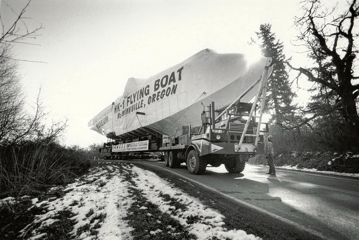 Spruce Goose. A black and white photo of the fuselage of the Spruce Goose being transported down the road towards McMinnville, Oregon.