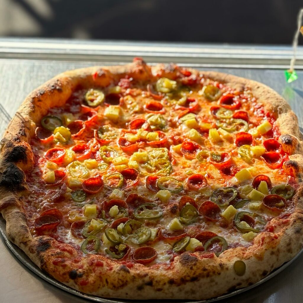 An absolutely delicious and unique looking pizza at Paladin Pie. Golden window light is shining down on it. It's got pepperoni and peppers. This thing looks so good!
portland oregon, best restaurants, 2024, where to eat, best brunch, food and drink, bars, pizza, sushi, thai food, PDX, foodie heaven