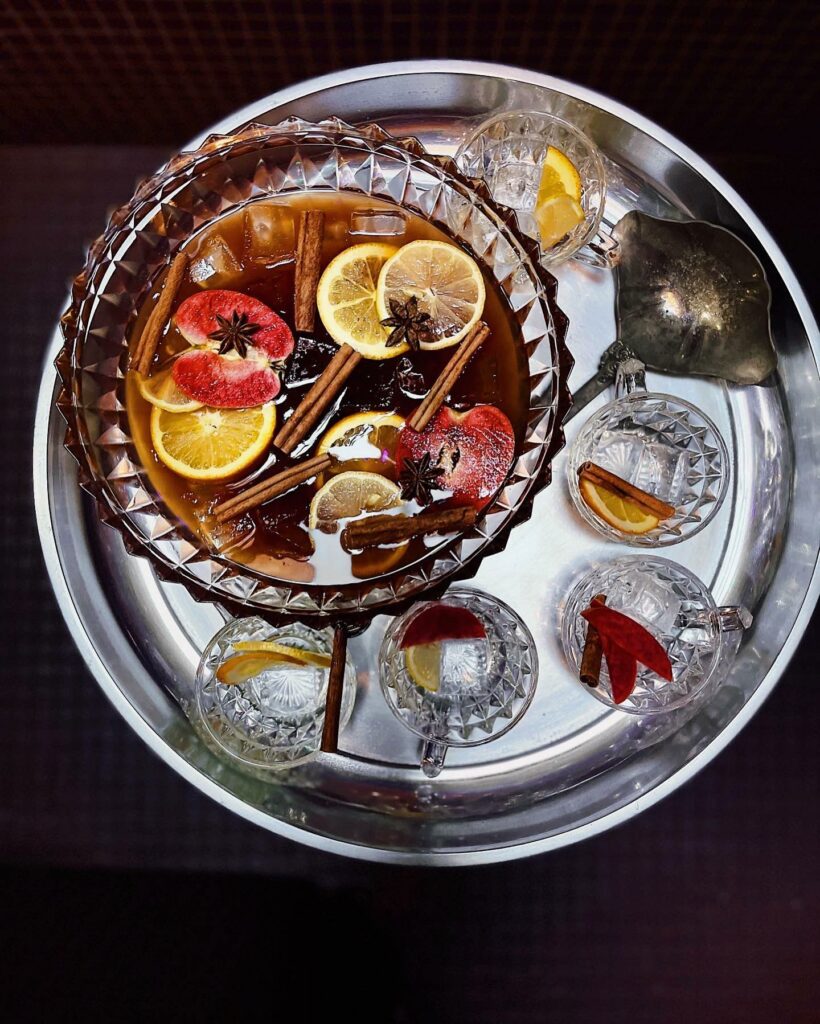 A colorful alcoholic drink with a variety of colorful fruit and cinnamon sticks in it. It's in a large pitcher and is surrounded by glasses on a metal serving tray.
portland oregon, best restaurants, 2024, where to eat, best brunch, food and drink, bars, pizza, sushi, thai food, PDX, foodie heaven