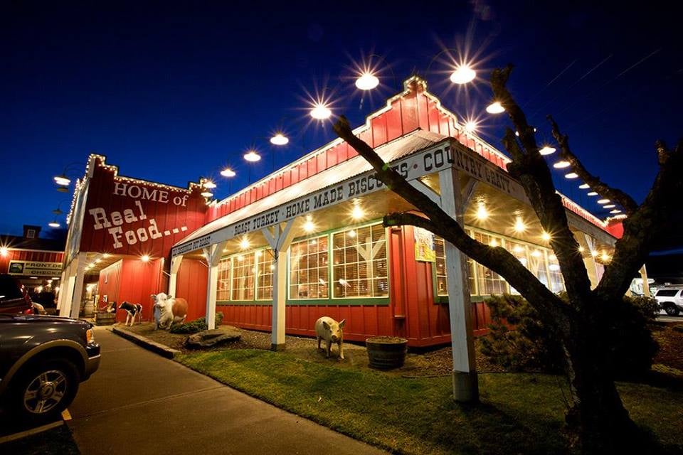 Photo by Cousins’ via Yelp. The exterior of Cousins' Restaurant in The Dalles Oregon. It's a red barn style building with white trim. It looks very cute.