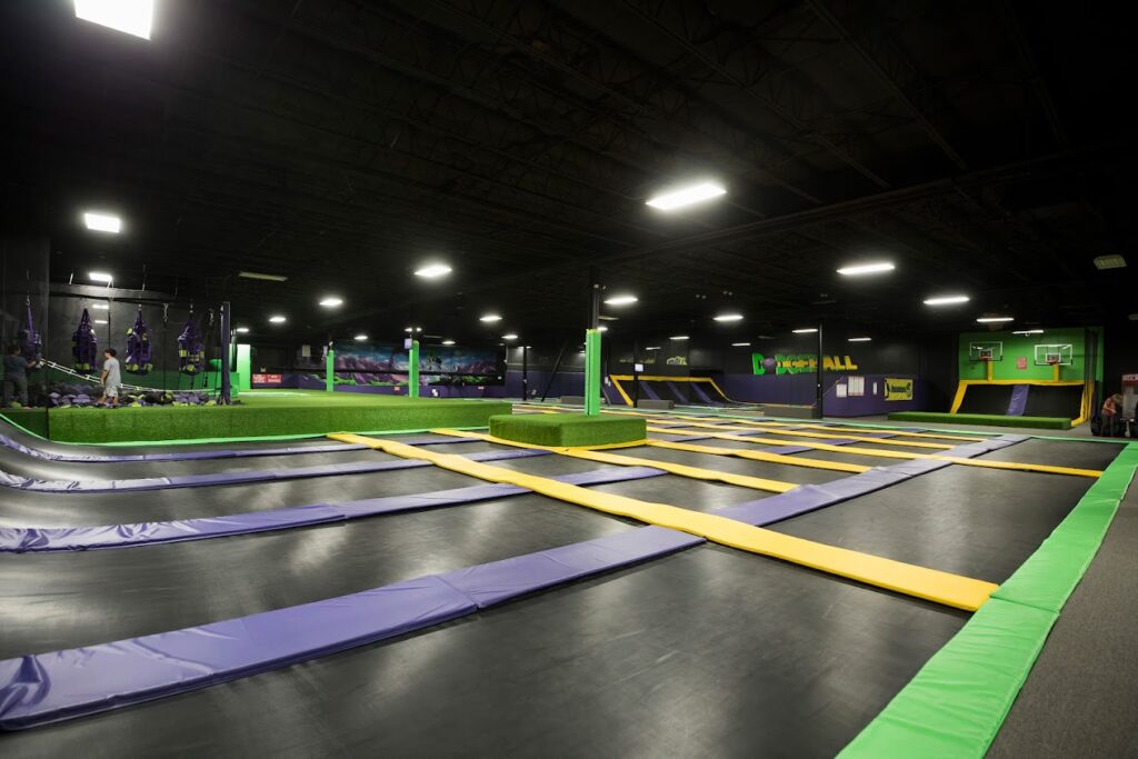 Trampolines cover the floors in a huge, wide open indoor space.