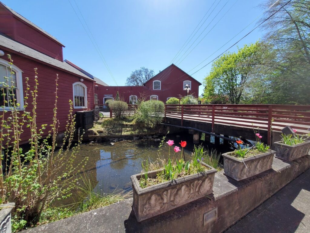 A huge red building with a bridge going over a small river.