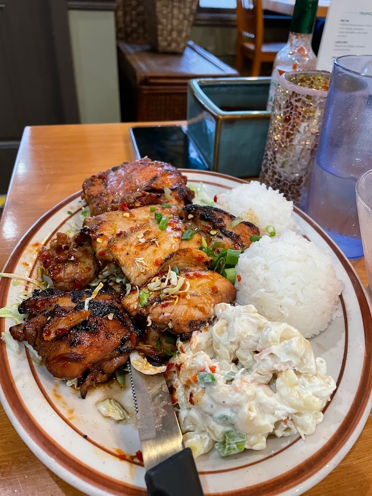 A plate with mac salad, sticky rice and marinated meat with chopped green onion on top.