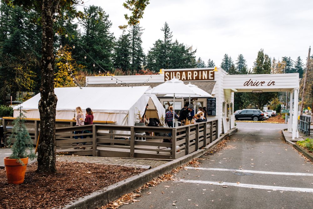 The outside of Sugarpine Drive-In. It's a white building with a cute sign.