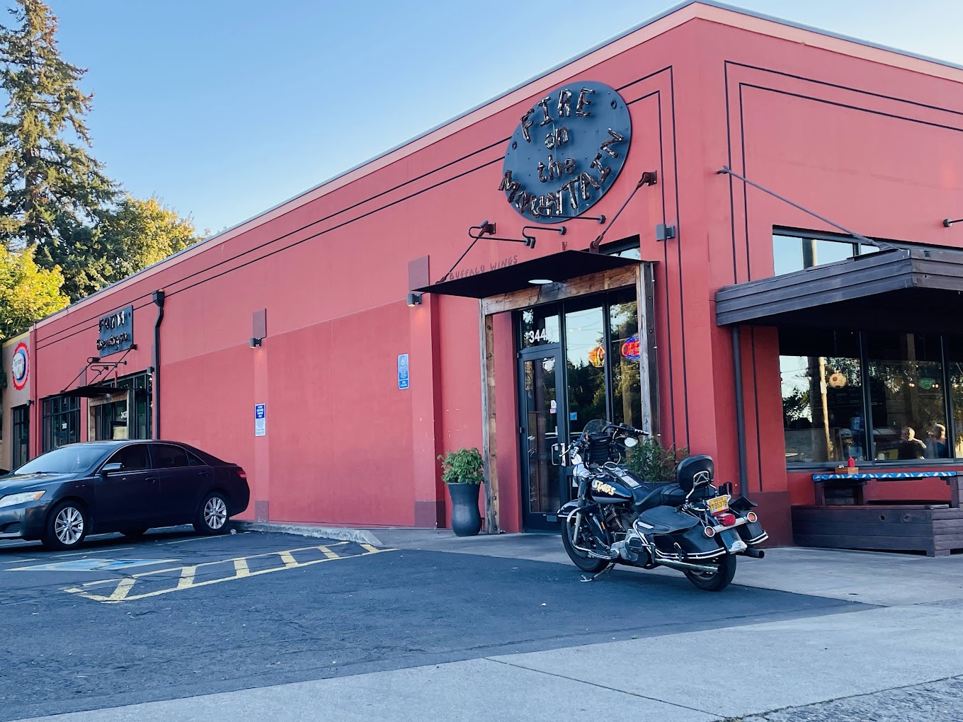The exterior of Fire On The Mountain restaurant in Portland Oregon. Photo by Jessica Vescogni via Google Local. The outside of Fire On The Mountain. This location has a red building with a black sign.