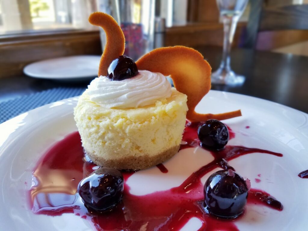 A really nicely plated fine dining desert with berries and a red sauce.
