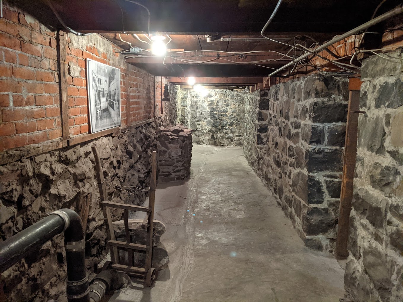 Photo by Larry Cebula via Google Local. A long brick tunnel under ground with a wooden ceiling.