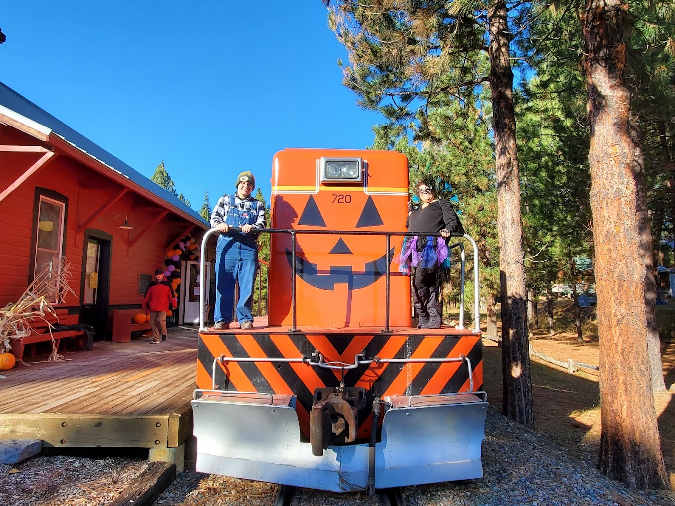 Photo by Michele Shopland via Google Local. Two people stand on an orange train painted to look like a jack-o-lantern