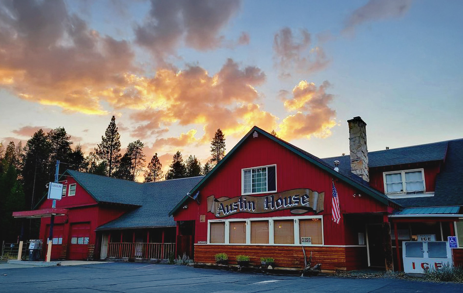 Photo by Austin House via Google Local. Austin House at sunset. Austin House is bright red. There are trees and fluffy clouds in the background.