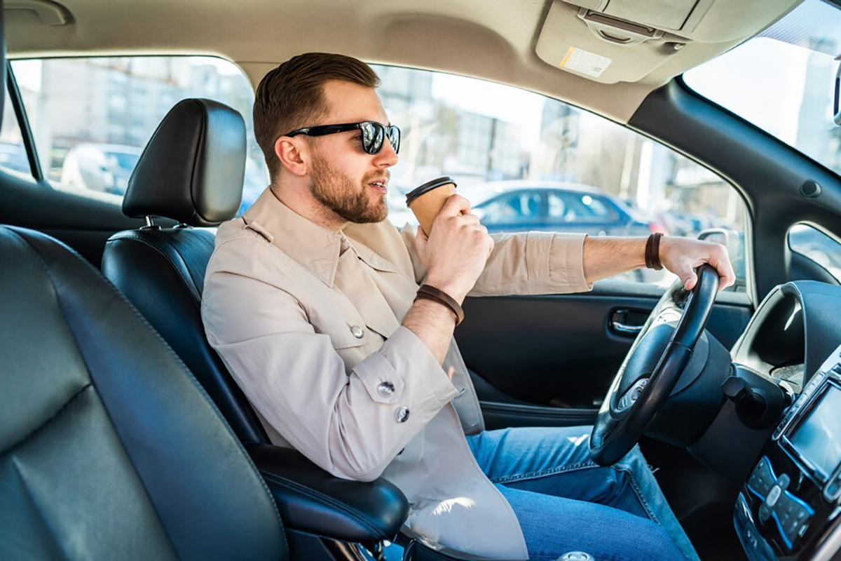 successful-man-driving-car-with-cup-coffee-his-hand_153608-3083