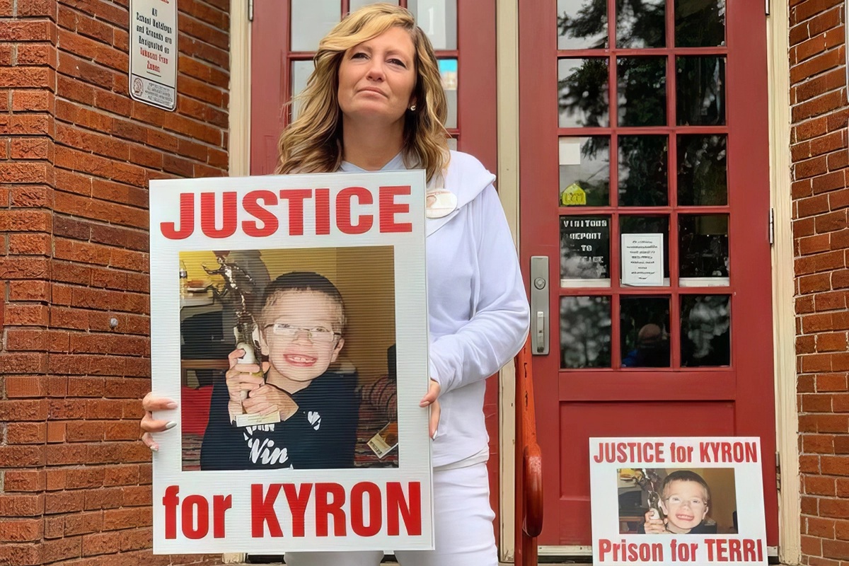 kyron Horman 2025 Desiree Young, Kyron Horman's mother, stands on the steps of Skyline Elementary School. She holds a large sign with Kyron's photo that reads "JUSTICE FOR KYRON".