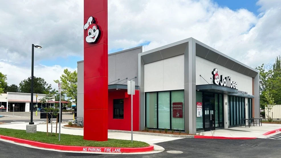 Jollibee Hillsboro. Photo by Jollibee The exterior of a Jollibee restaurant. The building is boxy and modern looking, with gray paint, large windows, and splashes of bright red color.