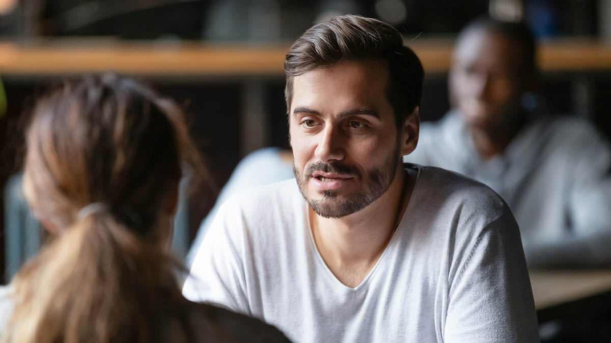 Young,Serious,Man,Having,Conversation,With,Woman,Girlfriend,Sit,At a man mildly interested
