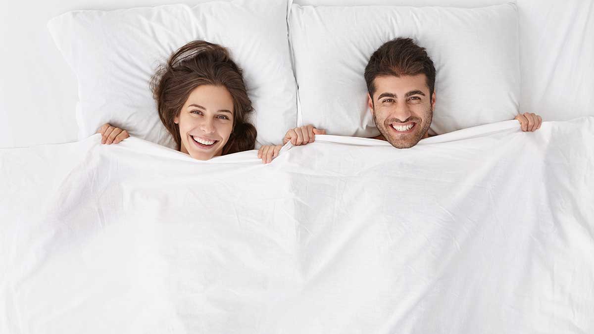 pound-town Happy couple laying in bed together