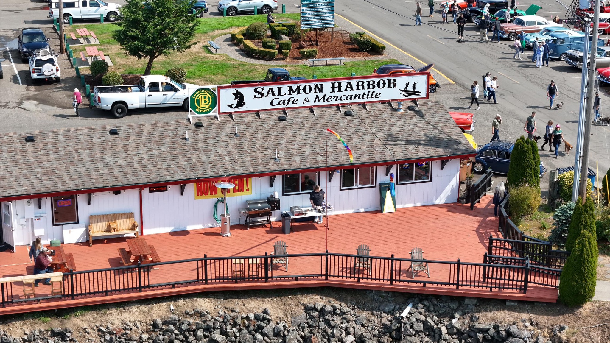 Photo via the Salmon Harbor Facebook page An aerial photo of Salmon Harbor Cafe and Mercantile. It's a white building with a gray roof, and a large white sign with black letters and a red border.