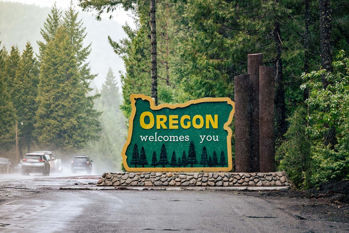 Oregon,Welcomes,You,Sign,At,State,Line.,Us-hwy,199,Redwood Oregon welcomes you sign at state line. US-HWY 199 Redwood Highway in rain.