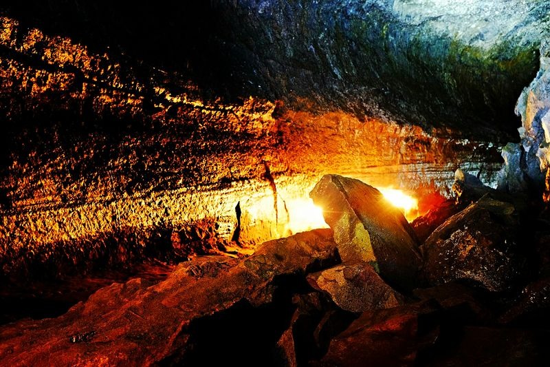 Lava River Cave interior illuminated by warm light highlighting ancient volcanic rock walls in Oregon lava tube