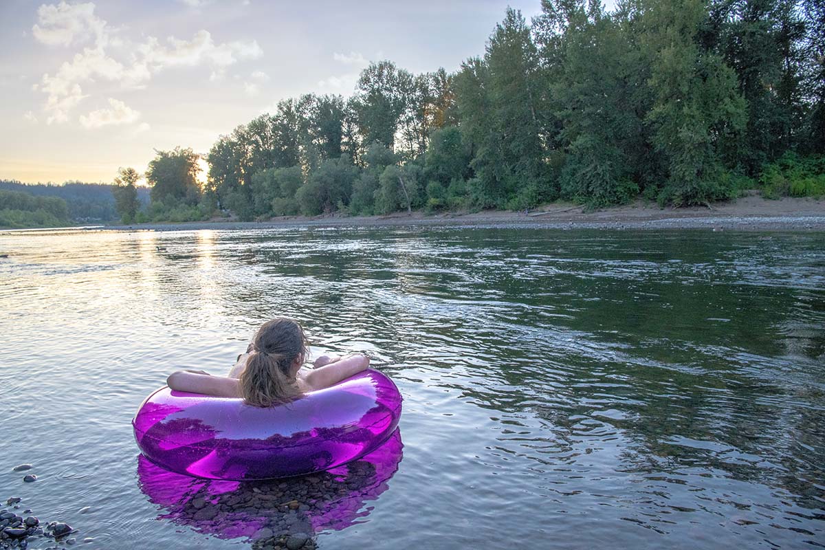 Woman,Sits,In,A,Colorful,Floating,Tube,At,The,River’s floating the river on an inner tube