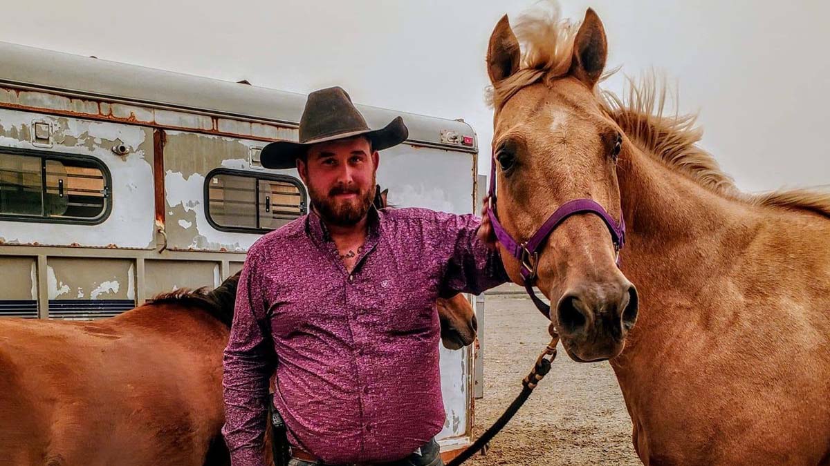 trevor_arrest_lemmings Trevor Alan Slocum-Lammers stands beside two horses near a horse trailer in an outdoor setting in Oregon.