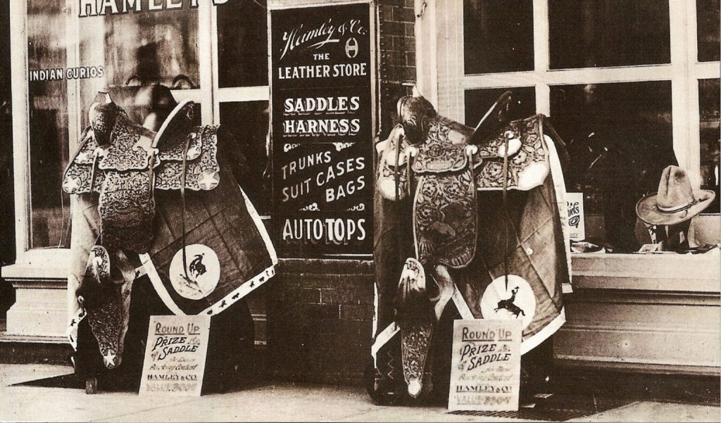 A historic photograph of two Hamley prize saddles in front of their store.
